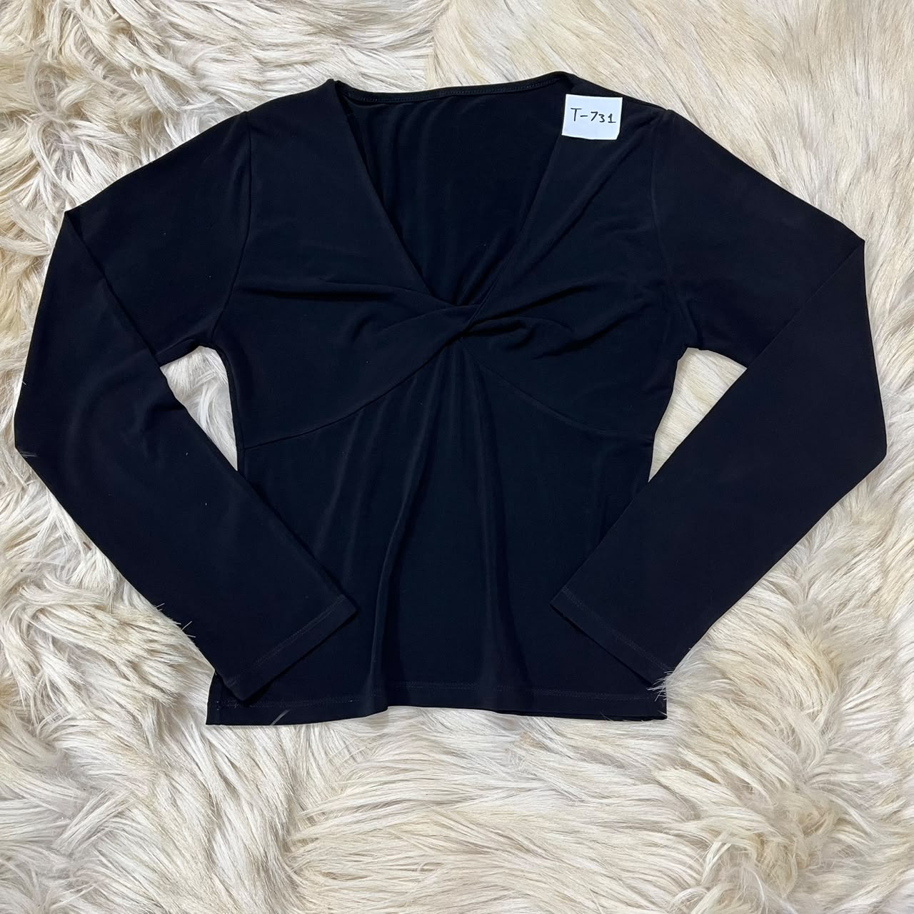 Black long-sleeve top with a twisted front detail