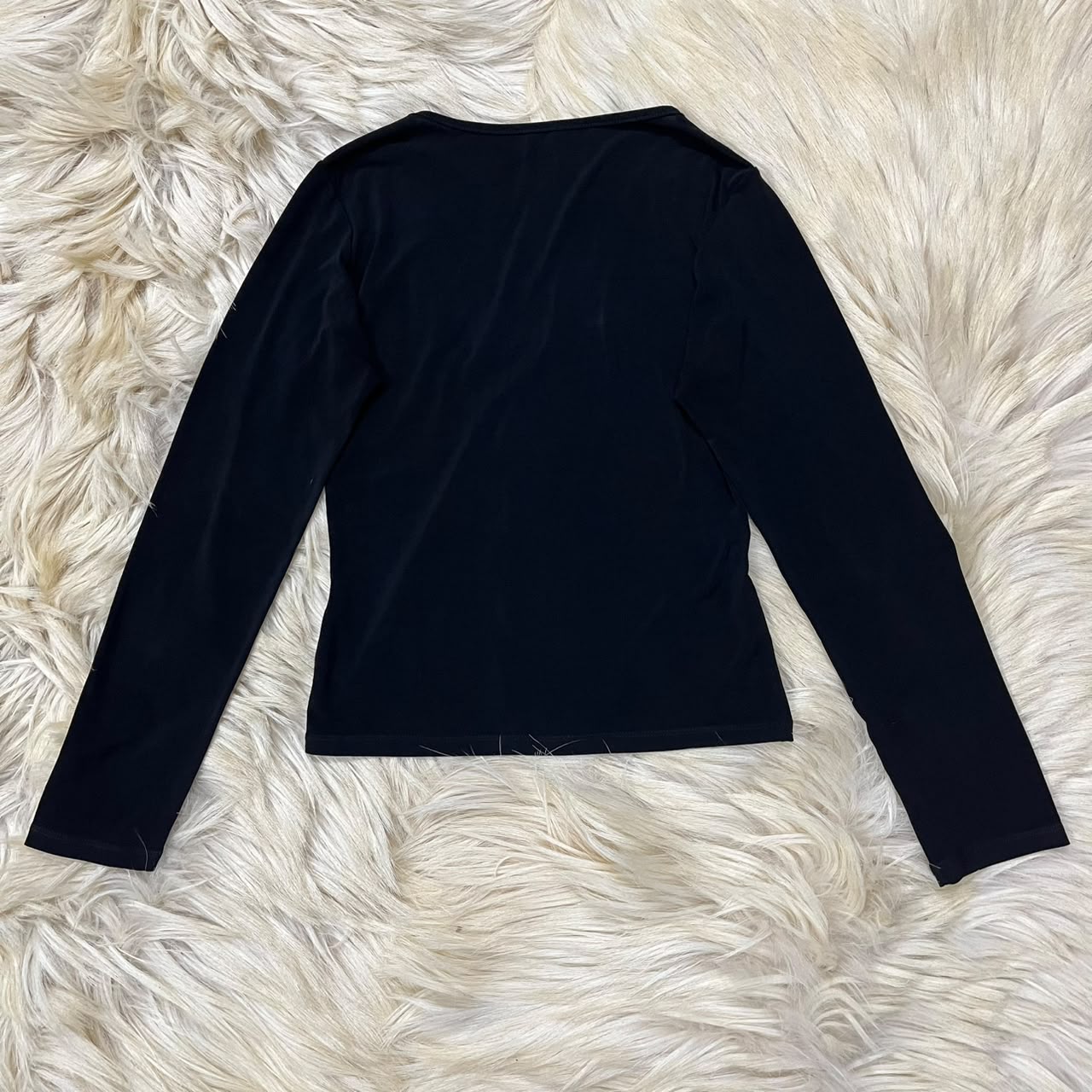 Black long-sleeve top with a twisted front detail